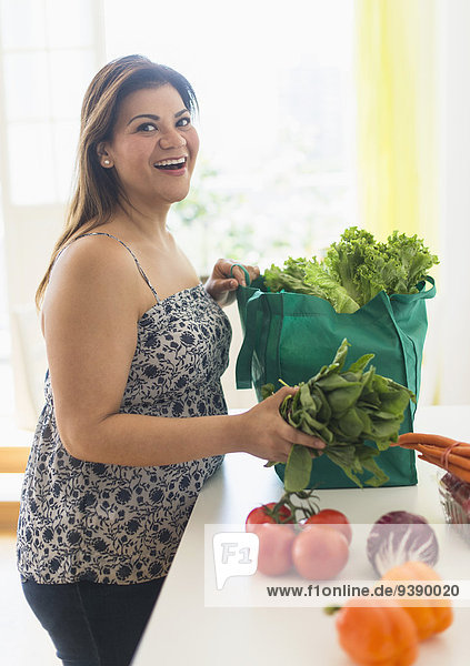 Frau Tasche Lebensmittelladen Gemüse herausnehmen