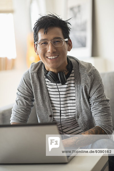 Portrait of man with headphones in front of laptop