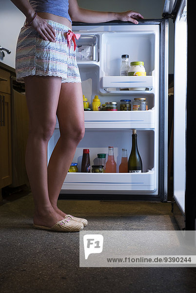 niedrig Anschnitt stehend Frau offen frontal Kühlschrank