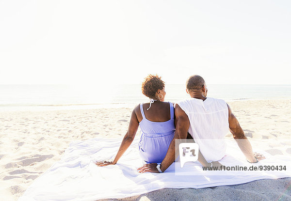 sitzend Strand Mann und Frau