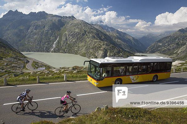 Postbus  riding a bicycle  Grimsel Pass  glacier  ice  moraine  bicycle  bicycles  bike  riding a bicycle  racing bicycle  canton Bern  Switzerland  Europe  man  woman