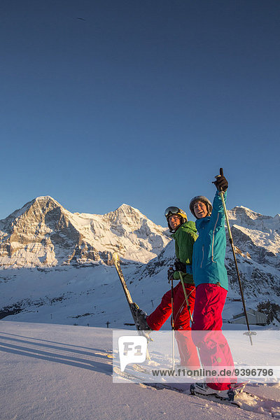 Frau Berg Winter Mann Fröhlichkeit schnitzen Skisport Ski Berner Alpen Abenddämmerung Mönch Wintersport