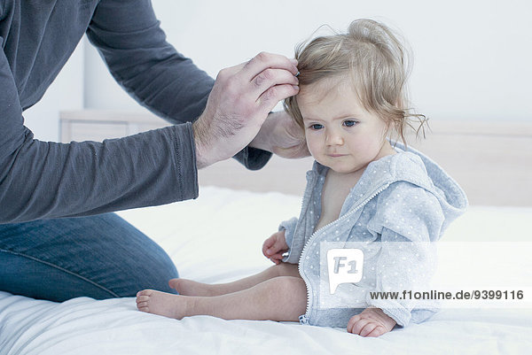 Father fixing baby girl's hair  cropped