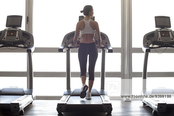 Woman jogging on treadmill at gym