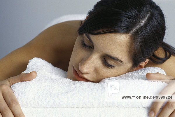 Woman resting head on folded towels  eyes closed