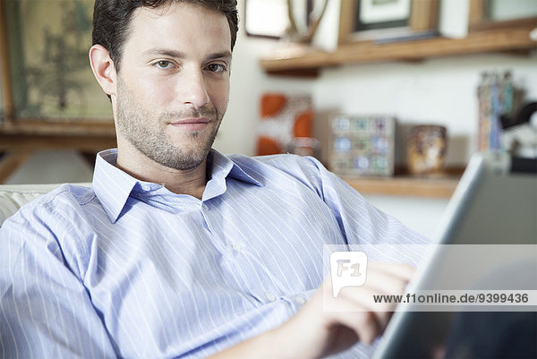 Mann mit digitalem Tablett zu Hause