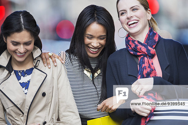 Frauen, die zusammen auf der Straße lachen.