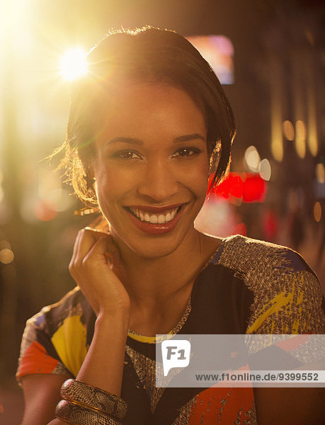 Frau lächelt nachts auf der Stadtstraße
