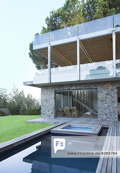 Modernes Haus mit Blick auf Swimmingpool und Holzdeck