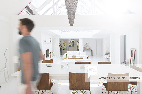 Blurred view of man walking in modern dining room