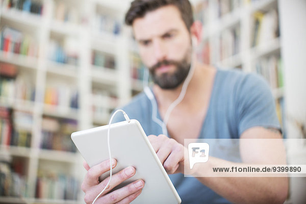 Close up of man listening to music on digital tablet