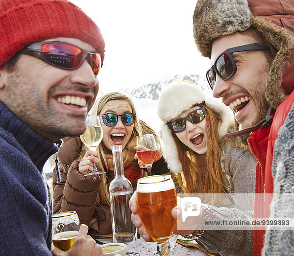 Freunde feiern mit Getränken im Schnee