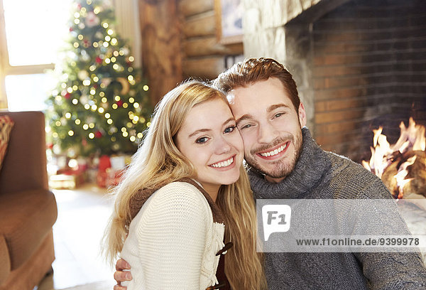 Couple hugging in front of fireplace