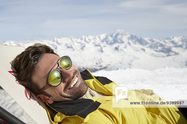 Mann auf einem Stuhl im Schnee liegend