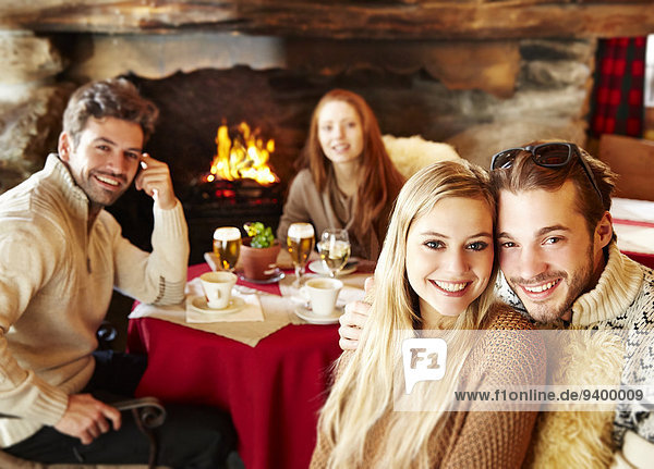 Freunde beim gemeinsamen Essen am Kamin