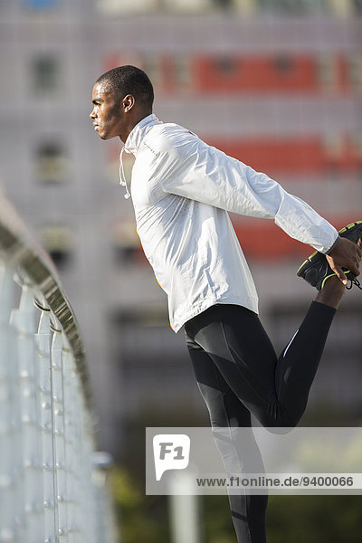 Mann  der vor dem Training die Beine streckt