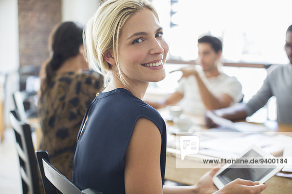 Geschäftsfrau mit digitalem Tablett beim Treffen im Cafe