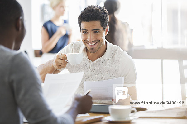 Businessman drinking coffee at meeting in cafe