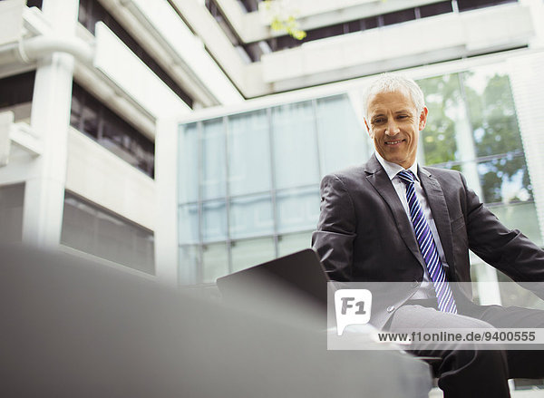 Geschäftsmann mit Laptop im Bürogebäude
