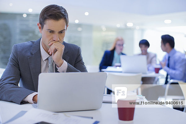 Geschäftsmann bei der Arbeit am Laptop am Tisch