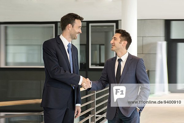 Two young business men shaking hands