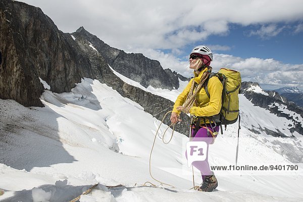 Woman moutaineer coils a rope on a glacier in North Cascades National Park.