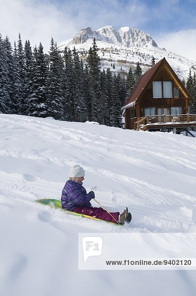 A young girl sledding near backcountry hut outside Silverton  Colorado.