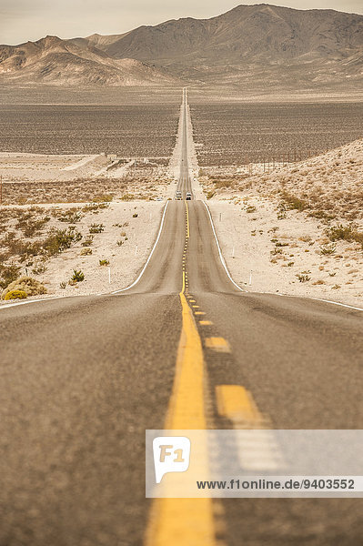 Vereinigte Staaten von Amerika USA Fluchtpunkt Gebirge Hochformat Außenaufnahme Landschaftlich schön landschaftlich reizvoll Berg Tag Ruhe Transport Landschaft niemand Tal Fernverkehrsstraße Wüste Nevada Death Valley Nationalpark Tiefenschärfe Linie Beatty Idylle Gebirgszug freie Natur