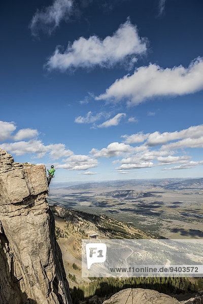 Mann Wand Seil Tau Strick über grün hängen Jacke Loch Kleidung Jackson Wyoming