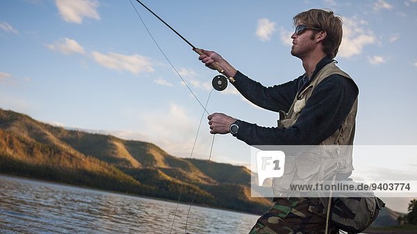 At The Edge Of Blonde Hair Carefree Casual Colorado day Durango fishing Fishing Rod Fly-Fishing Getting Away From It All Holding Horizontal Horizontal Leisure Activity mountain One Person One Young Man Only outdoors relaxation River Short Hair Side View