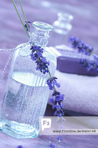 Lavendelblüte und Lavendelwasser in einer Glasflasche