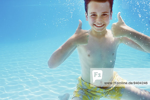 Portrait des Jungen mit Daumen nach oben unter Wasser