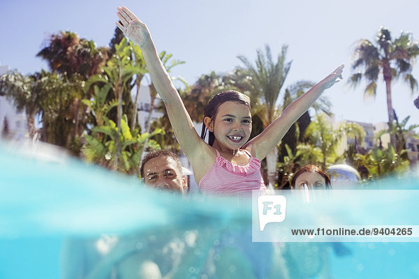 Eltern mit Tochter beim Spielen im Schwimmbad