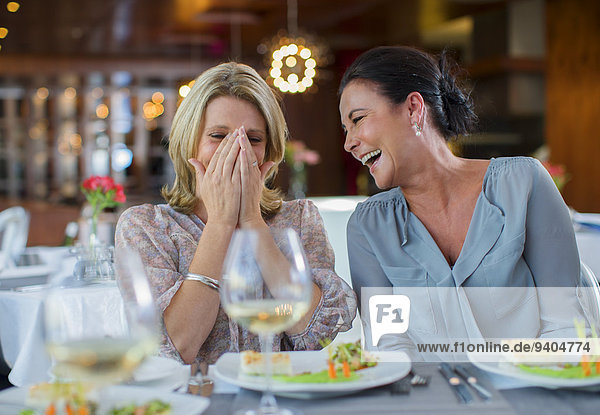 Zwei reife Frauen lachen im Restaurant