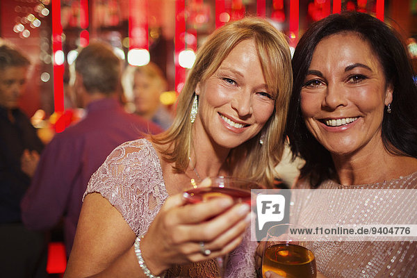 Portrait of smiling mature women enjoying drink in bar