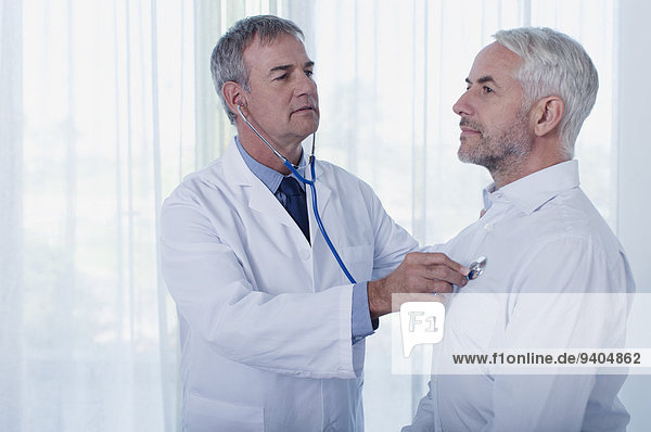 Arzt untersucht reifen Mann mit Stethoskop