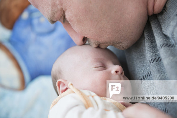 Father kissing his sleeping son  close up