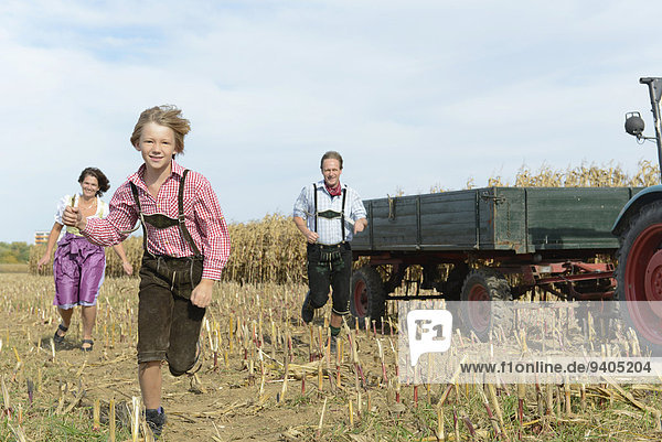 Family running in cornfield