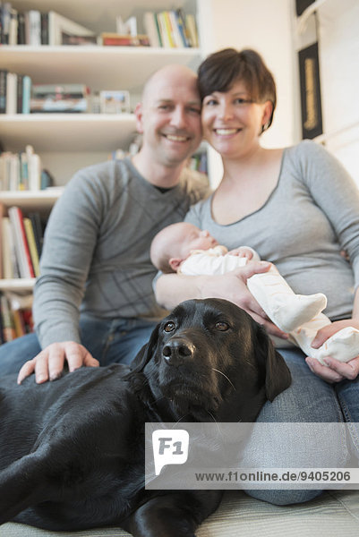 Portrait of family with baby boy and dog  smiling