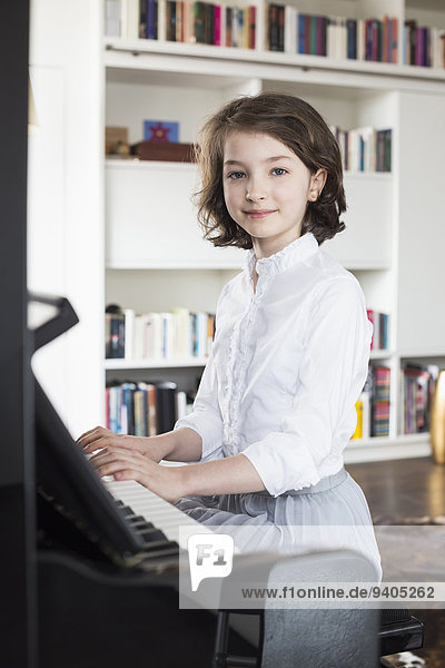 Portrait of girl playing piano  smiling