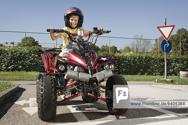 Happy boy with quadbike on driver training area