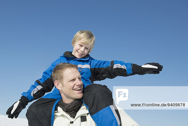 Father carrying son on shoulder  smiling