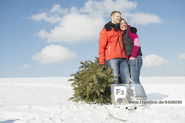 Couple standing with spruce  smiling