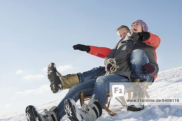 Mature couple riding sledge  smiling