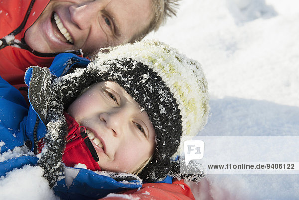 Father and son having fun in snow  smiling  portrait