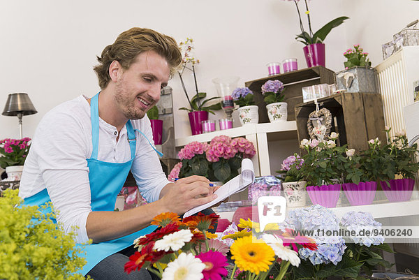 Mann Prüfung Blume lächeln Mittelpunkt Laden Erwachsener