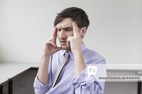 Businessman with headache in office