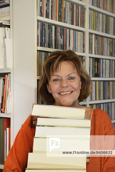 Senior Senioren Portrait Frau Buch lächeln Stapel