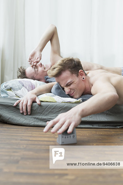 Homosexual couple awaken from ringing alarm clock