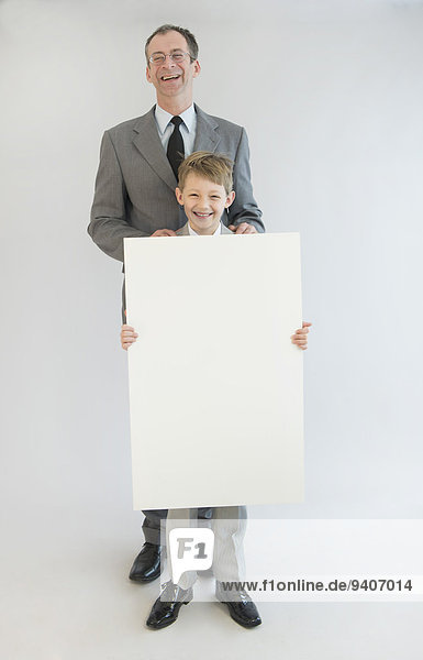 Portrait lächeln Menschlicher Vater Sohn halten Weißwandtafel unbeschrieben